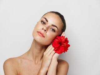 Fototapeta na wymiar pretty woman holding red flower in hands cropped view cosmetics isolated background