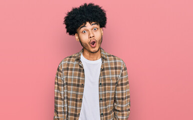 Obraz na płótnie Canvas Young african american man with afro hair wearing casual clothes afraid and shocked with surprise expression, fear and excited face.