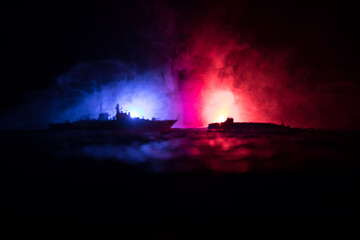 Silhouettes of a crowd standing at blurred military war ship on foggy background. Selective focus. Passengers try to escape. Protest of people