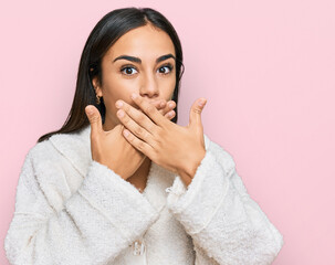 Young brunette woman wearing casual clothes shocked covering mouth with hands for mistake. secret concept.