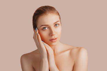 Beautiful sensual young girl with clean skin on a beige background with a mockup. Topless woman. The concept of spa treatments, natural beauty and care, youth, cream and mask, freshness