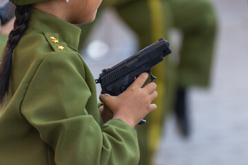 Child in uniform with a pistol.
