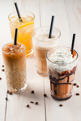 Set with different iced summer coffee drinks - espresso, frappe, latte, cappuccino, with whipped cream, syrup and crushed ice