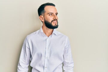 Young man with beard wearing business white shirt looking to side, relax profile pose with natural face and confident smile.