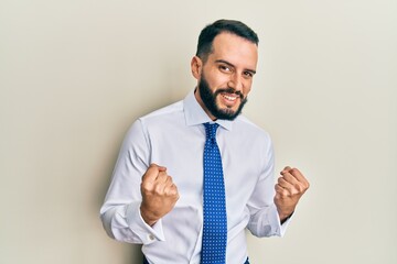 Young man with beard wearing business tie very happy and excited doing winner gesture with arms raised, smiling and screaming for success. celebration concept.