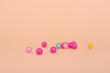 Colorful pearls spread on peach background