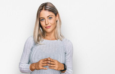 Beautiful blonde woman wearing casual clothes hands together and fingers crossed smiling relaxed...