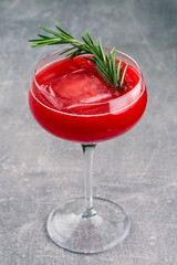 A refreshing fruit cocktail. A refreshing drink with a pulp of red berries, decorated with rosemary