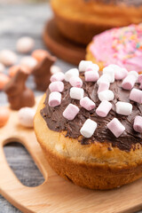 Homemade glazed and decorated easter pies on a gray wooden background and linen textile. Side view, selective focus.