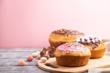 Homemade glazed and decorated easter pies on a gray wooden background and linen textile. Side view, selective focus, copy space.