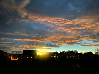 House settlement illuminated with renewable energy in the evening at sunset. Ecological heating and...