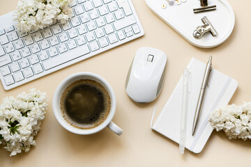 Neutral color tabletop with pc keyboard, notepad and white flowers, home office objects