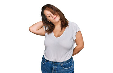 Fototapeta premium Young plus size woman wearing casual white t shirt suffering of neck ache injury, touching neck with hand, muscular pain