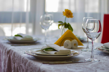 Sorting a table in a restaurant. Yellow rose and yellow napkins