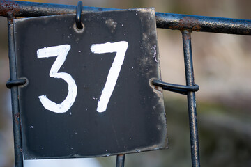 Tabliczka na ogrodzeniu z numerem 37