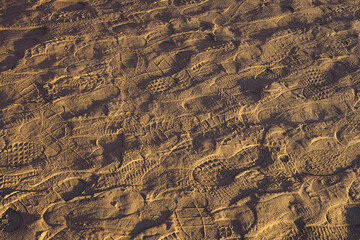 .A large number of different human footprints in the sand, background - 435138939