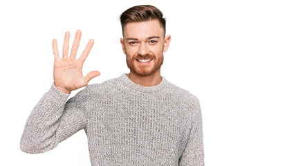 Young redhead man wearing casual winter sweater showing and pointing up with fingers number five while smiling confident and happy.