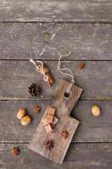 Pieces of chocolate, cinnamon sticks and star anise on a wooden board. High quality photo