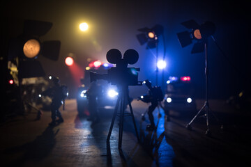 Action movie concept. Police cars and miniature movie set on dark toned background with fog. Police...