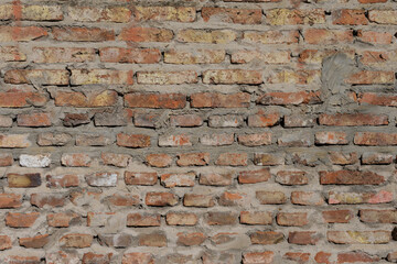 Old empty brick wall texture. Wall surface with plaster and paint problems. Grunge wall. Damaged wall. Copy space