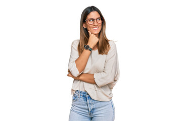 Young woman wearing casual clothes and glasses with hand on chin thinking about question, pensive expression. smiling with thoughtful face. doubt concept.