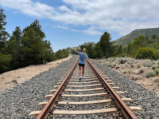 Woman walking on the rail track