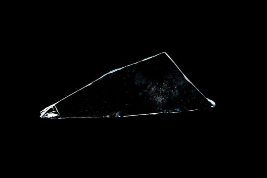 glass fragments in isolation on a black background. damaged window. damaged object