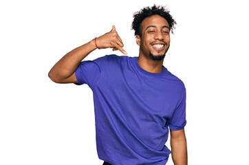 Young african american man with beard wearing casual purple t shirt smiling doing phone gesture with hand and fingers like talking on the telephone. communicating concepts.