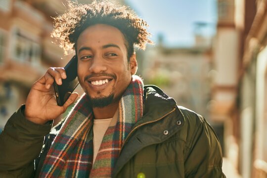 Young african american man smiling happy talking on the smartphone at the city