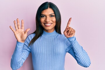 Young latin transsexual transgender woman wearing casual clothes showing and pointing up with fingers number six while smiling confident and happy.