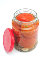 Salted tomatoes in a glass jar on a white background