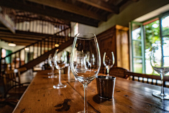 Close-up Of Wine Glasses In A Warm Setting. Nice Indoor With Wooden Furniture. Vineyard