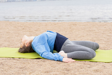 Young woman goes in for sports on the beach by the sea. Photo series