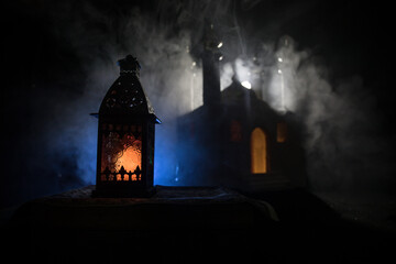 Fototapeta na wymiar Ornamental Arabic lantern with burning candle glowing at night. Festive greeting card, invitation for Muslim holy month Ramadan Kareem.