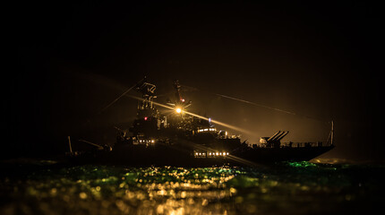 Silhouettes of a crowd standing at blurred military war ship on foggy background. Selective focus.