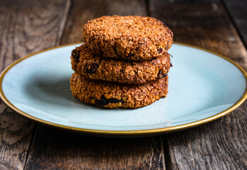 Homemade oatmeal cookies in a ceramic plate on the kitchen table.