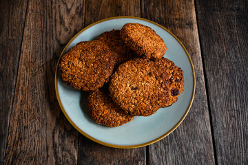 Homemade oatmeal cookies in a ceramic plate on the kitchen table.