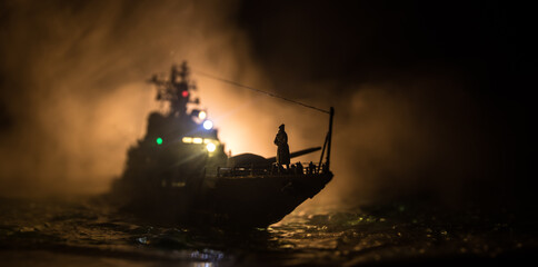 Silhouettes of a crowd standing at blurred military war ship on foggy background. Selective focus.