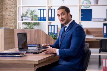 Fototapeta premium Young male bookkeeper working in the office