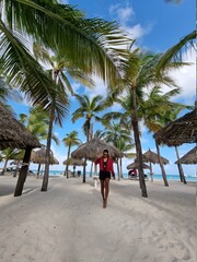 Palm Beach Aruba Caribbean, white long sandy beach with palm trees at Aruba Antilles, woman...