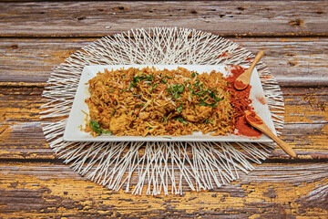 Rectangular tray of chicken rice and wooden spoons