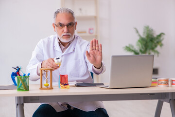 Old male dentist working in the clinic