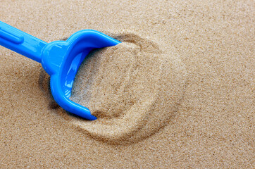 Plastic toys, shovel in sand. Summer background concept