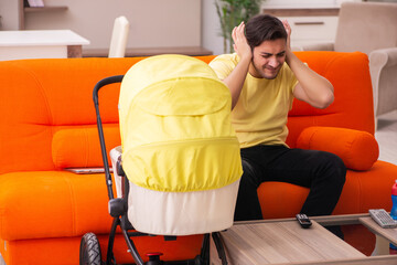 Young man looking after new born at home