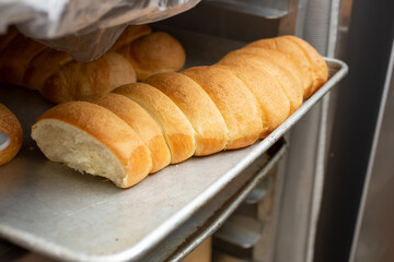 A view of a metal tray full of pull apart bread sticks, in a restaurant kitchen setting.