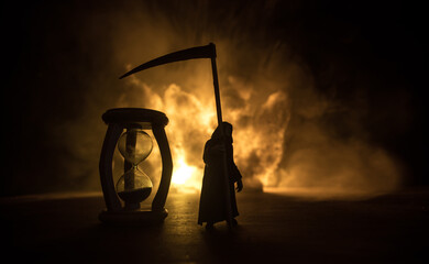 Time concept. Silhouette of Hourglass clock and old vintage wood clock with arrow and smoke on dark...
