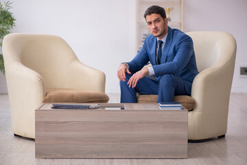 Young male employee waiting for business meeting