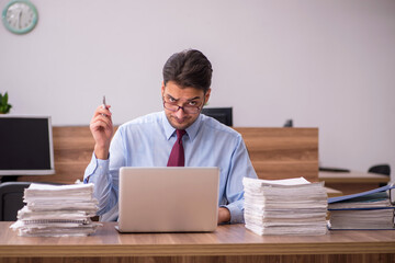 Young male employee unhappy with excessive work in the office