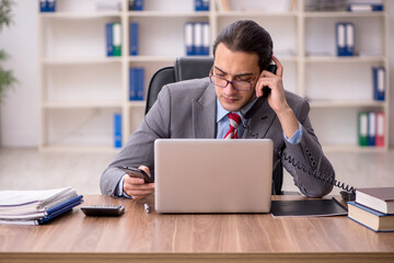 Young male employee sitting at workplace