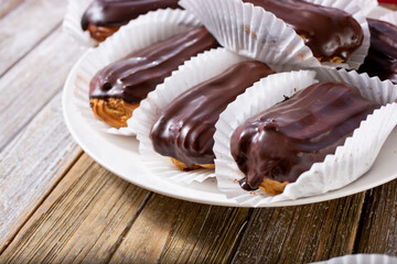 A view of a plate of chocolate eclair pastries.